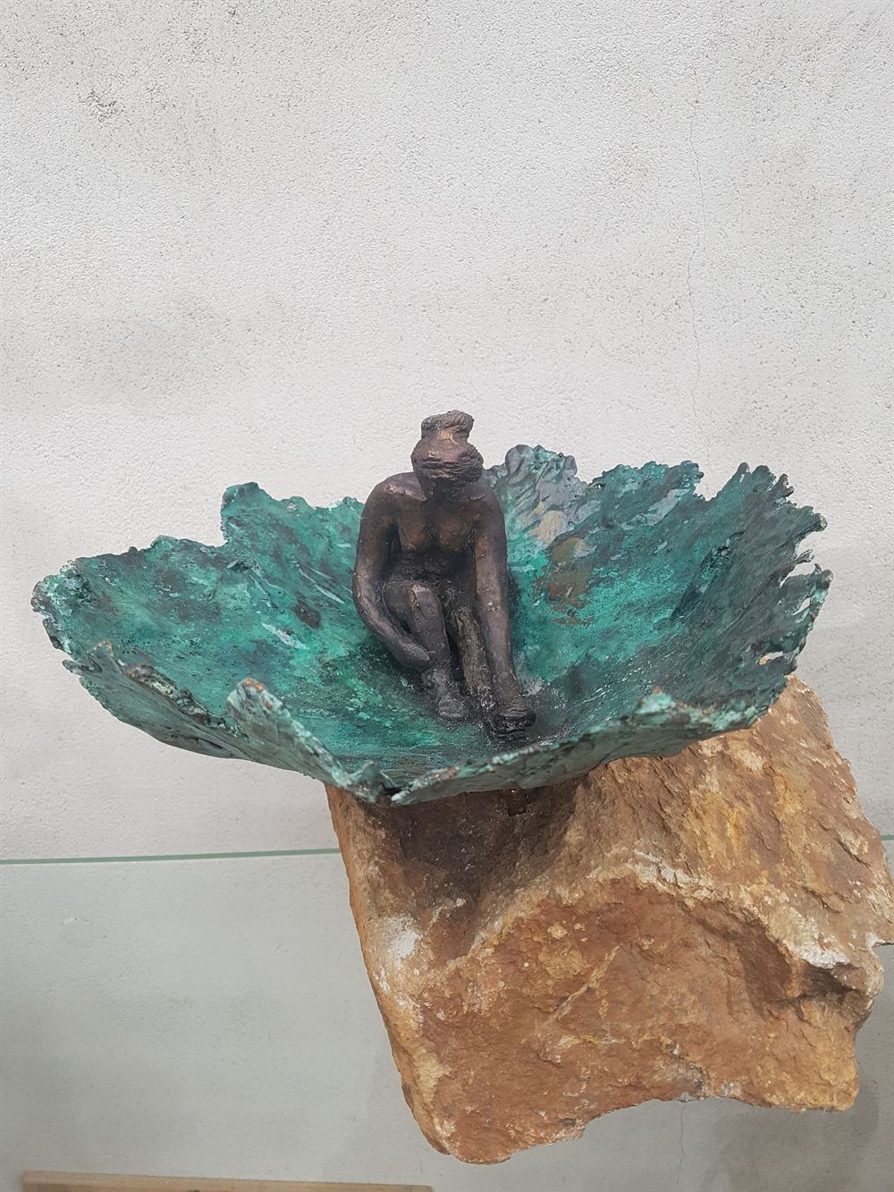 Bronzen schaal met een zittend figuurtje, op een ruw stuk natuursteen
