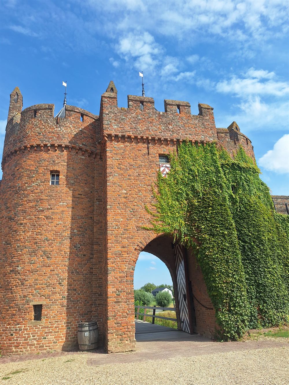 De bakstenen poorttoren van Kasteel Doornenburg, begroeid met klimop
